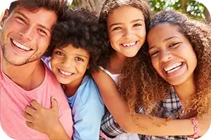 Happy family posing for a picture in the park.