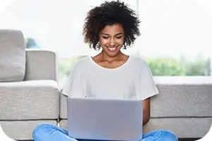 Young person looking at dental plans on her laptop.