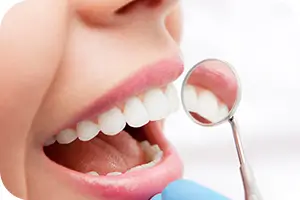 Dentist examining teeth with a small mirror.